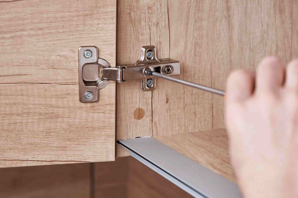 reparación de bisagras en un mueble de cocina